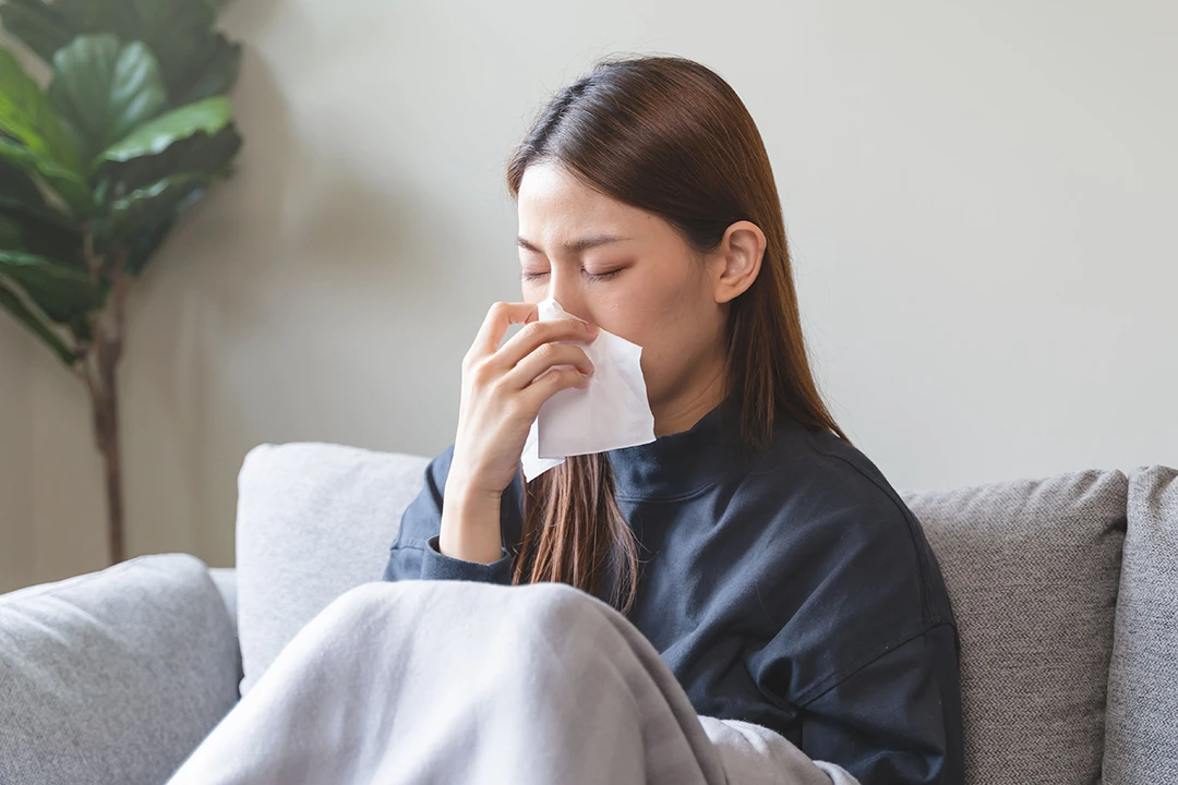 女性がシックハウスに罹り鼻水をかんでいる